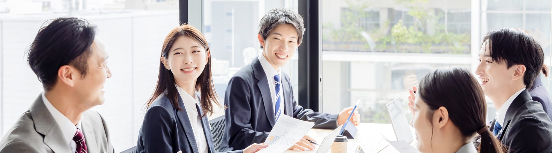 オフィスで談笑しながら打ち合わせする社員たち