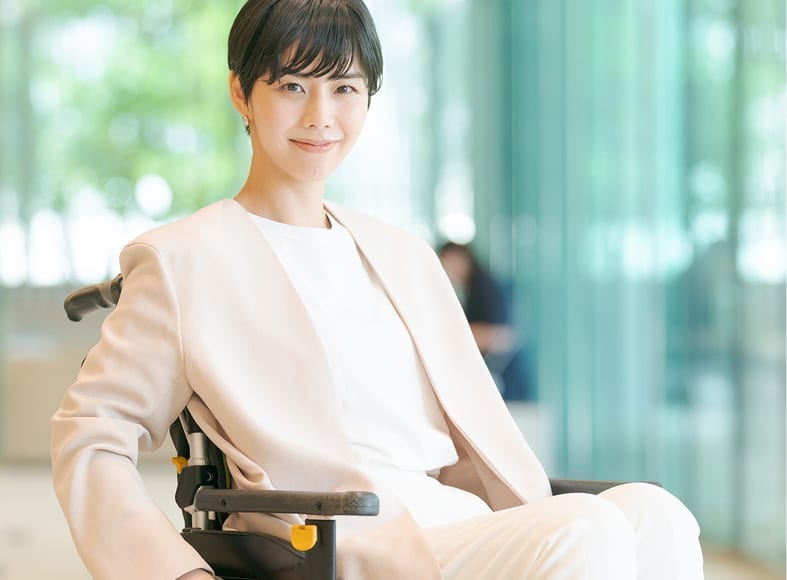 車椅子の社員がオフィスで笑顔の様子